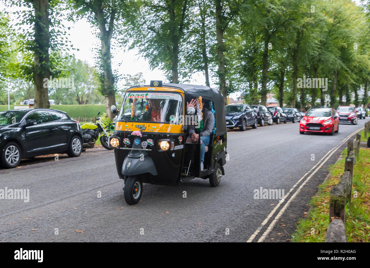 Le persone aventi una gita in un Piaggio Ape City 3 carrello a ruote (comunemente noto come un Tuk Tuk Veicolo) da Arundel, West Sussex, Regno Unito. Foto Stock