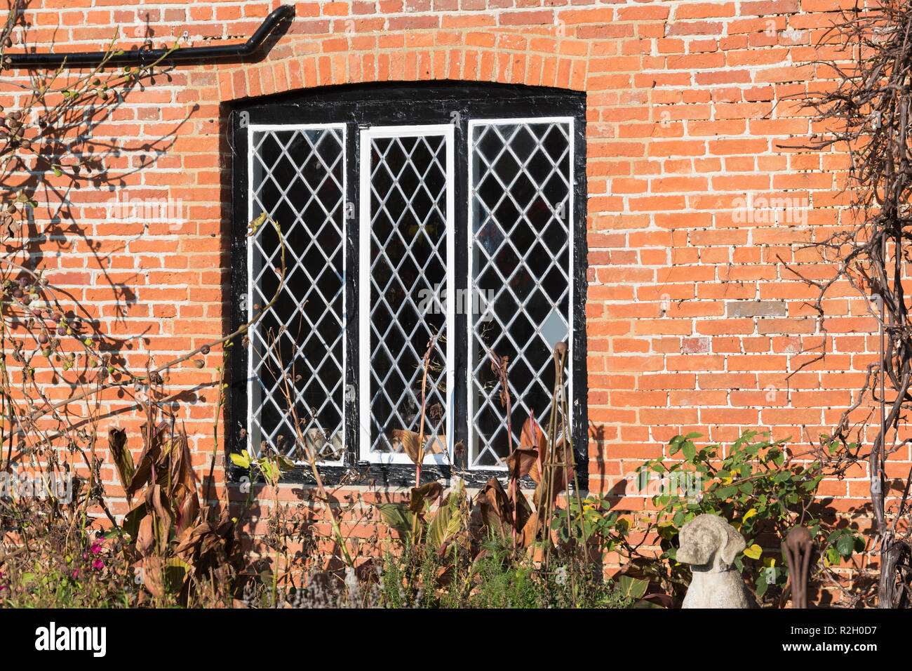 Diamante a forma di piombo in vetro con cornice finestra su un muro fatto di mattoni rossi, nel Regno Unito. Lead frame diamante windows. Foto Stock
