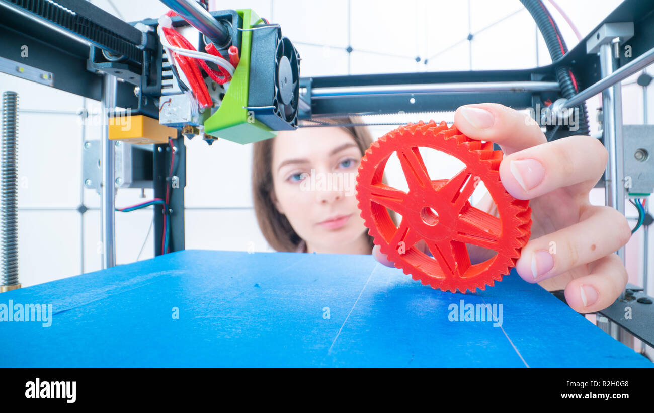 Giovani donne designer in 3d laboratorio di stampa. Ragazzina prende il particolare finito dalla stampante 3D Foto Stock