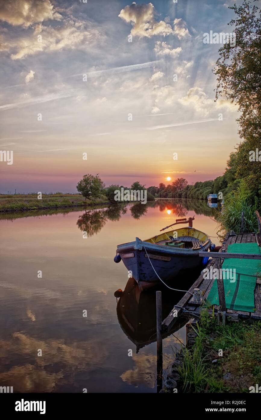 Imbarcazione attraccata ad un molo su un affluente del fiume Ems, Oldersum, Frisia orientale, Bassa Sassonia, Germania Foto Stock