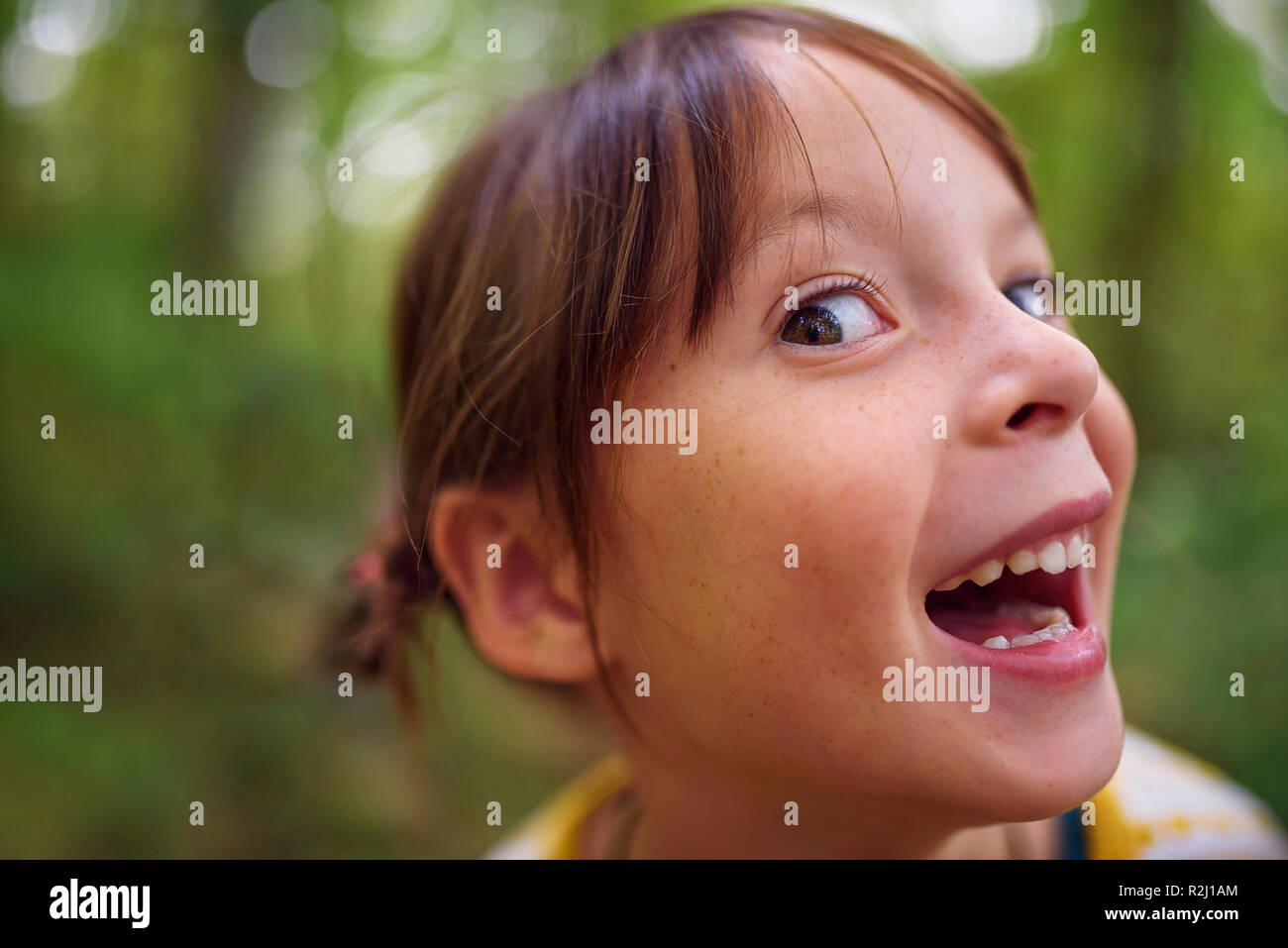 Ritratto di una ragazza sorridente in piedi all'aperto tirando facce buffe, Stati Uniti Foto Stock