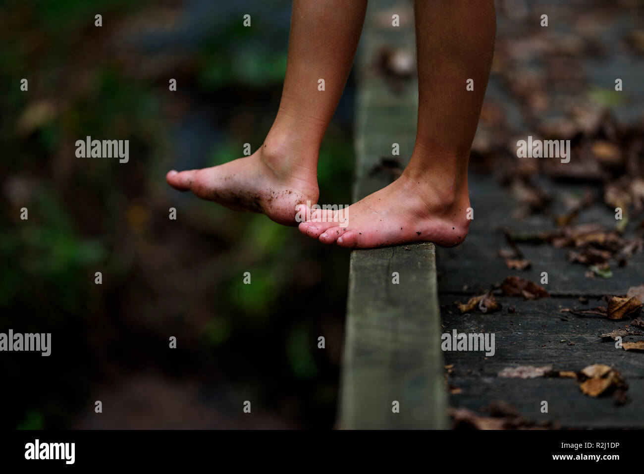 Close-up di un ragazzo in piedi sporchi in piedi su un ponte pedonale in foresta, Stati Uniti Foto Stock