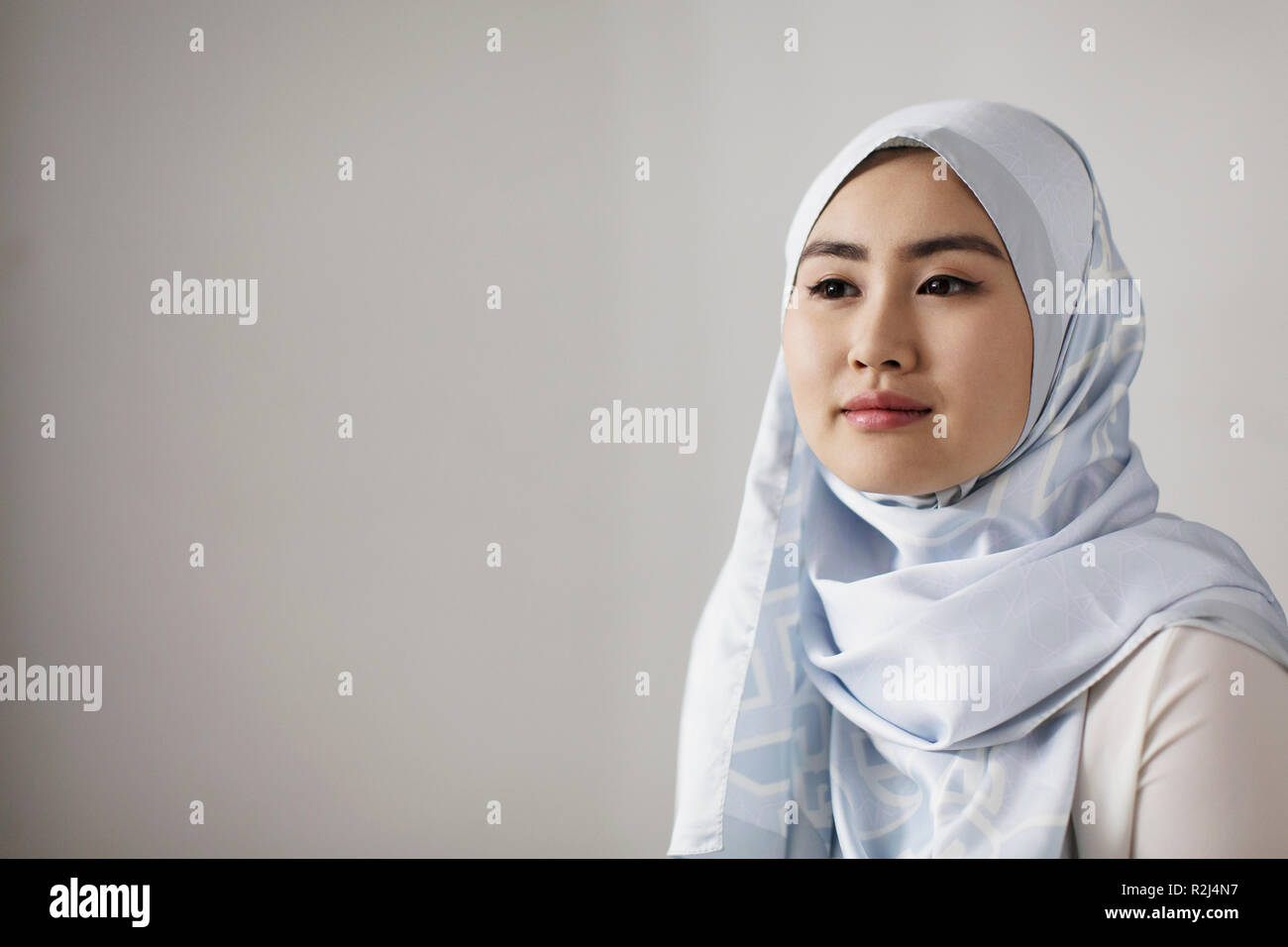 Serena Ritratto di giovane donna in seta blu hijab guardando lontano Foto Stock