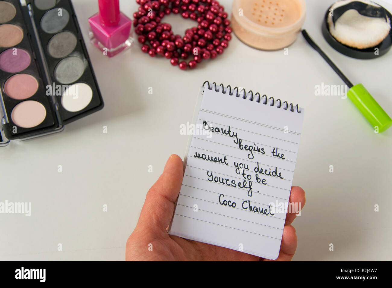 Donna Mano Trattiene Coco Chanel Preventivi Scritti Su Un Blocco Note Perla Accessori E Make Up Su Sfondo Bianco Ispirazione La Frase Bellezza Inizia Il Foto Stock Alamy