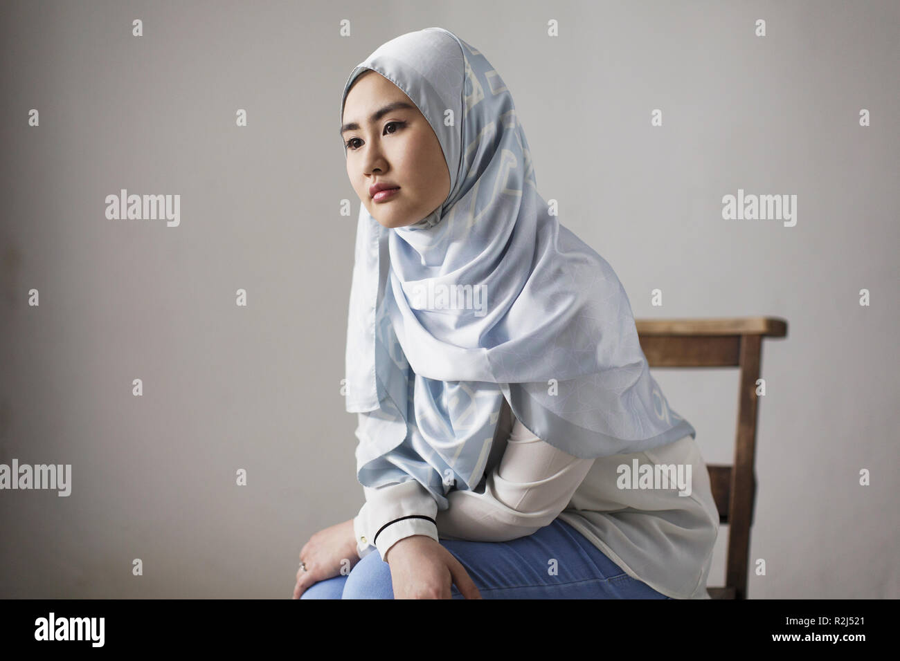 Considerato giovane donna in seta blu hijab Foto Stock