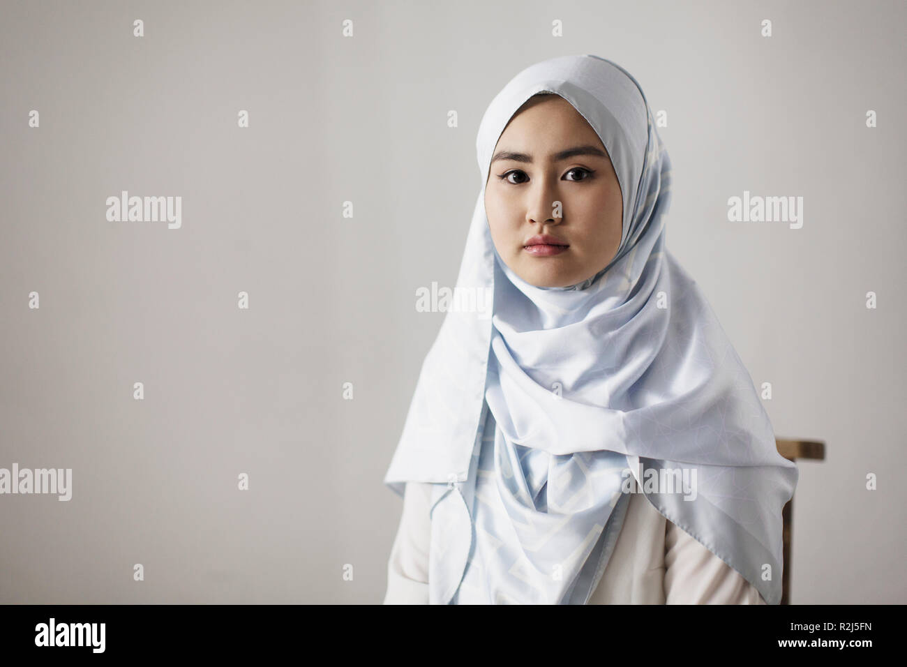 Ritratto fiduciosi, grave giovane donna indossa hijab Foto Stock