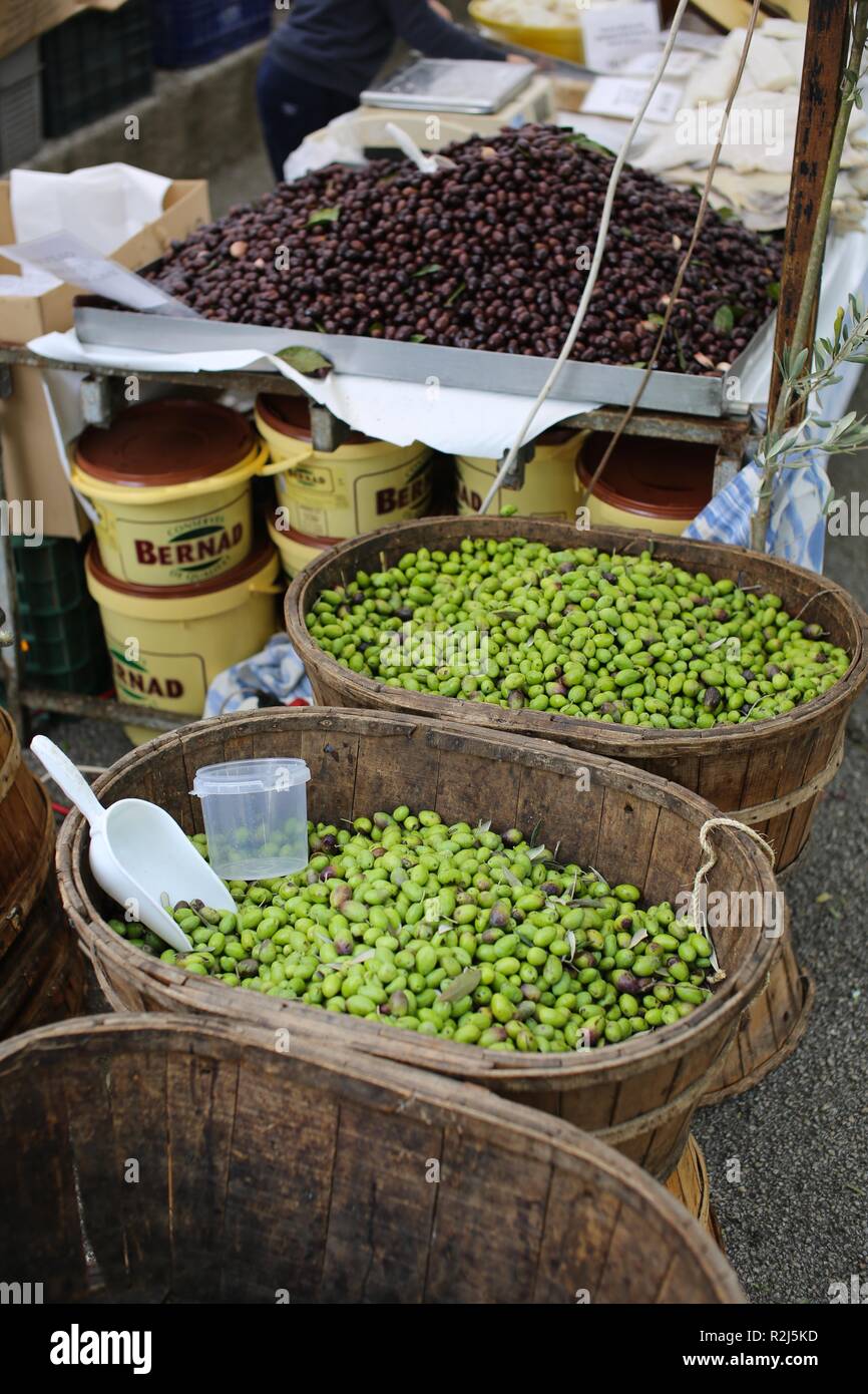 Olive nere e verdi per la vendita nel mercato mediterraneo visualizzati in cesti in legno Foto Stock
