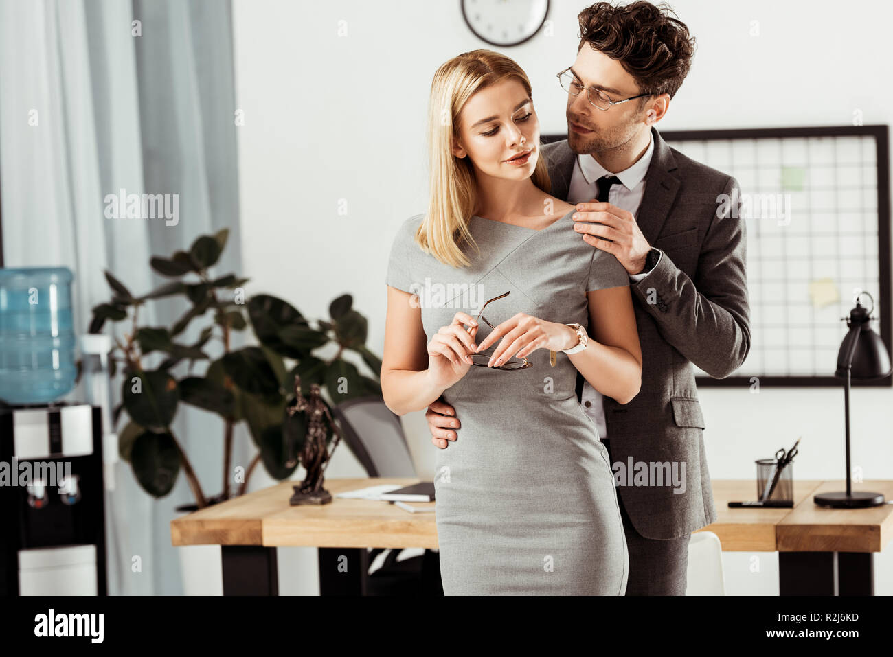 Giovani avvocati flirtare durante la giornata di lavoro in ufficio, ufficio concetto romantico Foto Stock