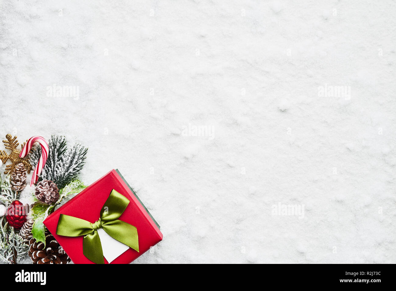 Vista superiore di verde e rosso regalo di Natale scatola con nastro e decorazione sulla neve. Copia spazio per il testo. Foto Stock