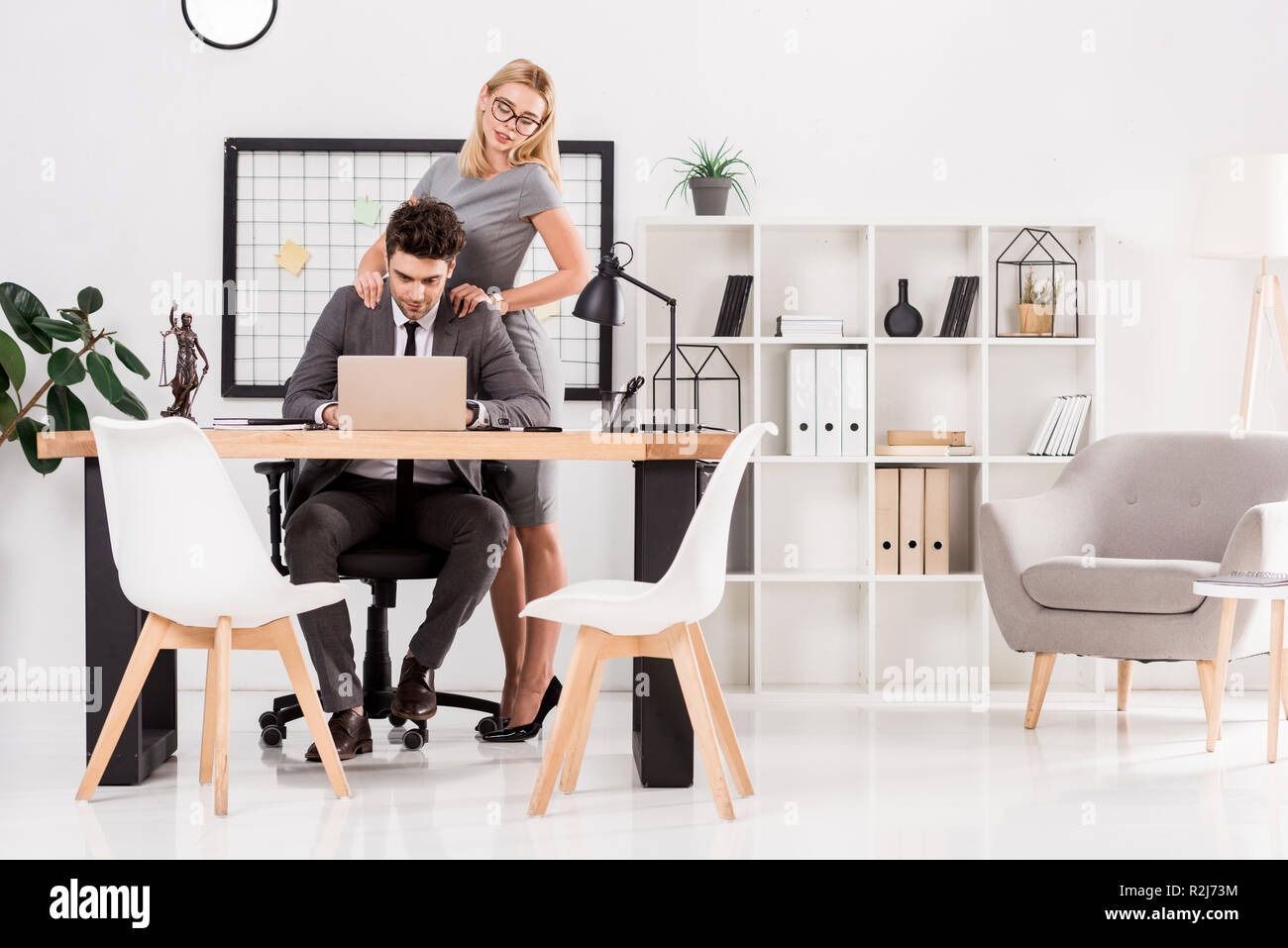 Imprenditrice massaggio a un collega sul posto di lavoro in ufficio, ufficio concetto romantico Foto Stock