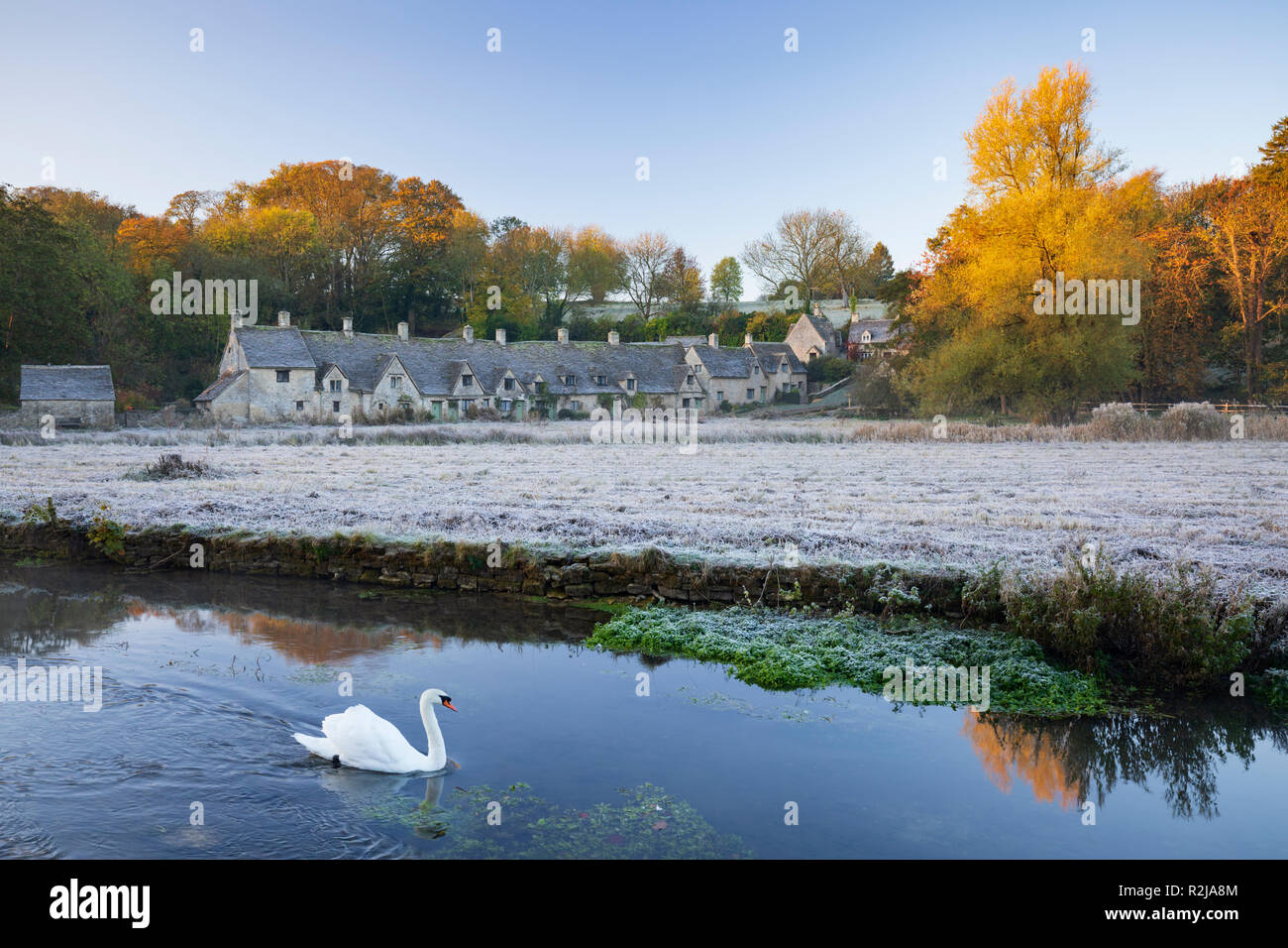 Arlington tipico di Riga cotswold cottage in pietra e del cigno sul Fiume Coln su frosty autunno mattina, Bibury, Cotswolds, Gloucestershire, England, Regno Unito Foto Stock