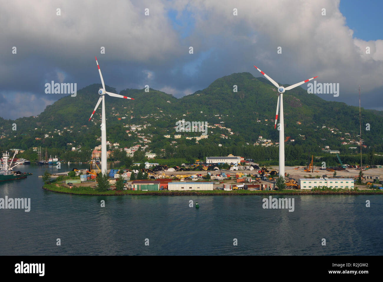 Costa del mare, i generatori eolici, le montagne e le nuvole. Victoria, Mahe, Seicelle Foto Stock