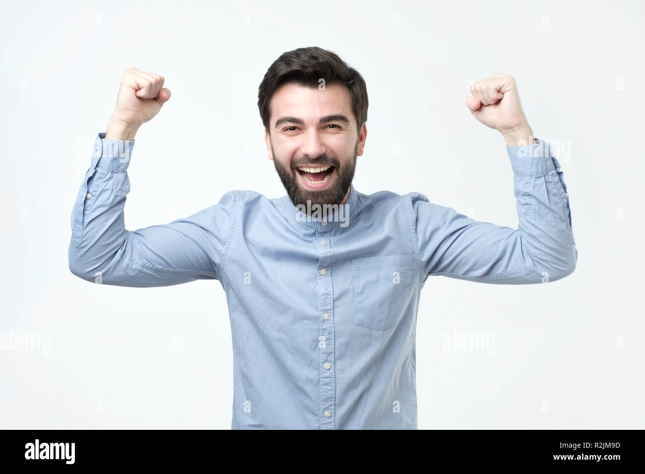 Ritratto di felice uomo spagnolo con i pugni fino per celebrare la sua vittoria Foto Stock