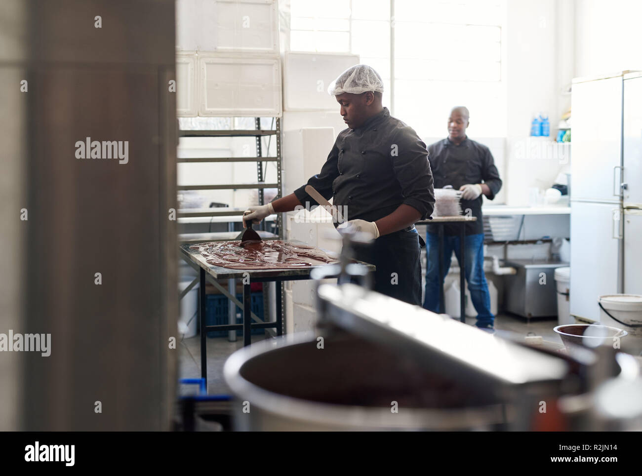 Lavoratore di cioccolato di raffreddamento in una confetteria rendendo la fabbrica Foto Stock