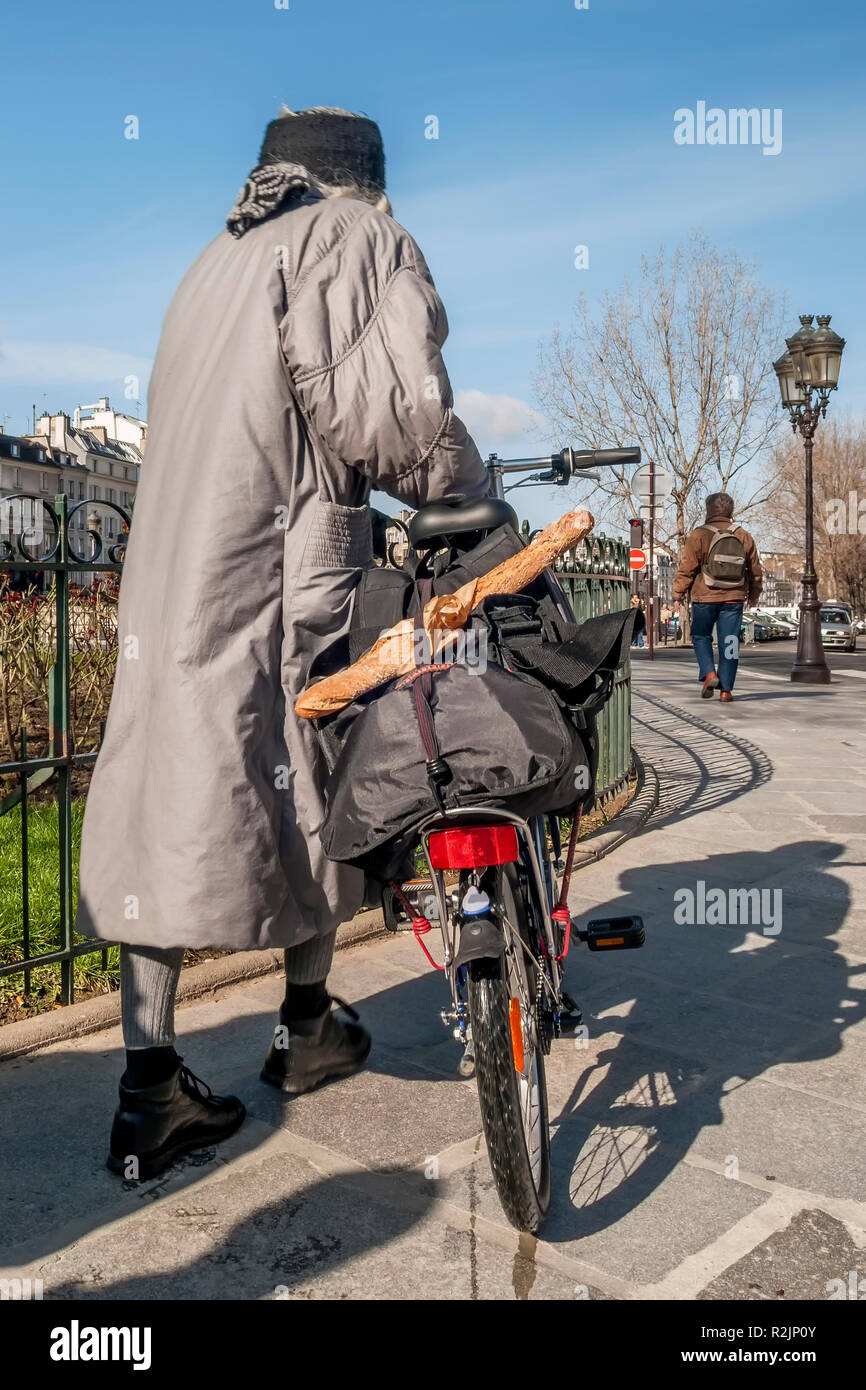 Donna con la bicicletta e la tipica baguette francese per le strade del  centro di Parigi, Francia Foto stock - Alamy