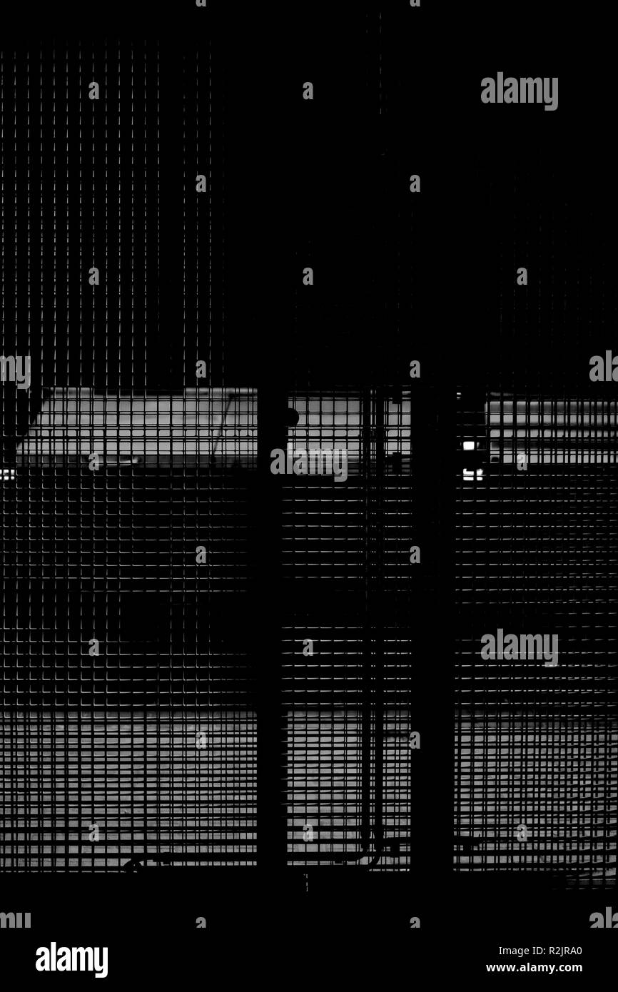 Contenitori per i rifiuti sono dietro un recinto di maglia in un chiudibile spazio all'aperto Foto Stock