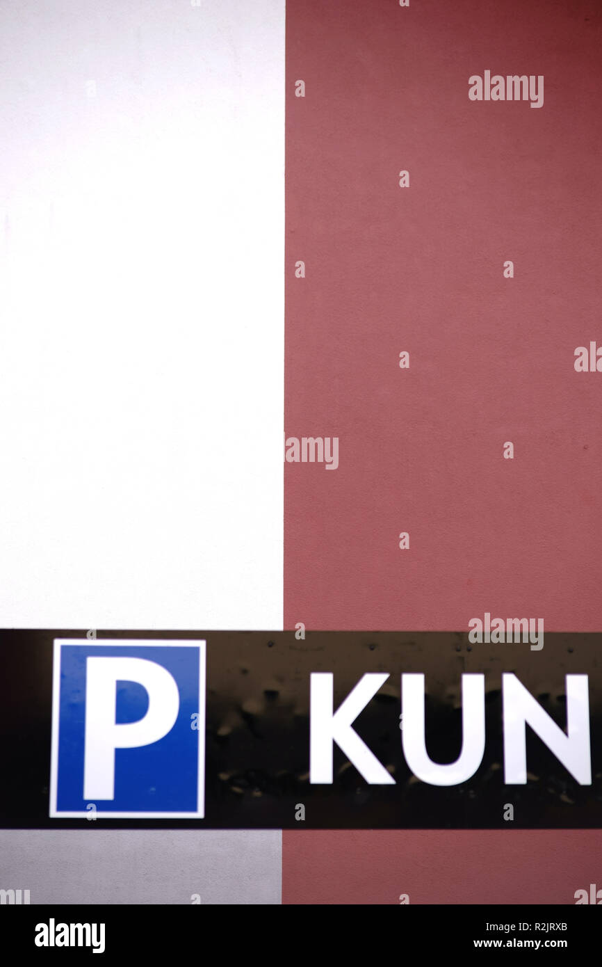 Simbolo di parcheggio per i clienti di un quartiere residenziale e edificio commerciale a fronte di un bi-colorata facciata moderna, Foto Stock