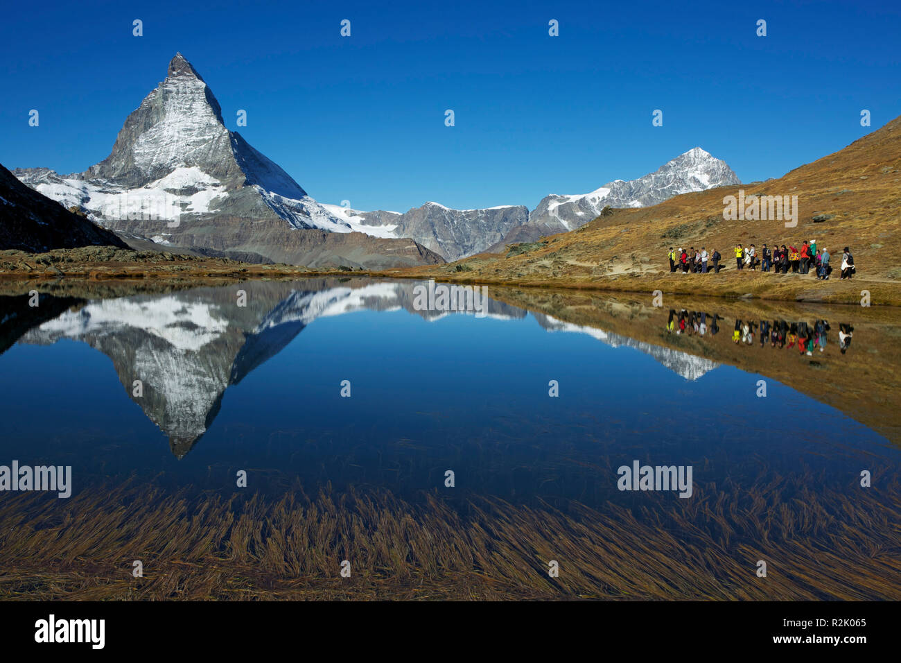 Vista sulla parte superiore Riffelsee vicino a Zermatt e il Cervino. A destra è la Dent Blanche e una partenza cinese gruppo turistico. Foto Stock