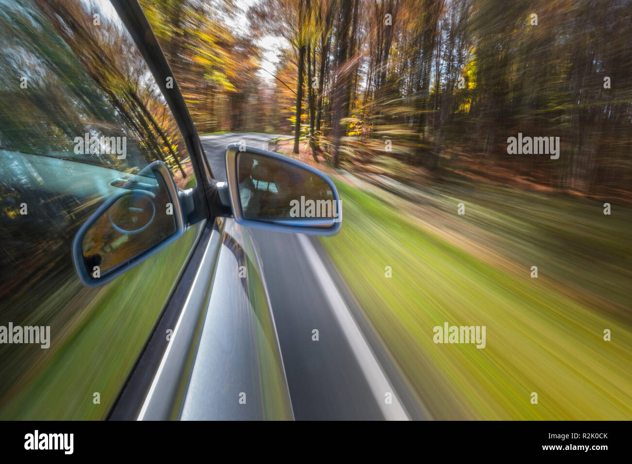 La guida con un auto su foglie di autunno, pericolosa la superficie stradale, pericolo di slittamento Foto Stock
