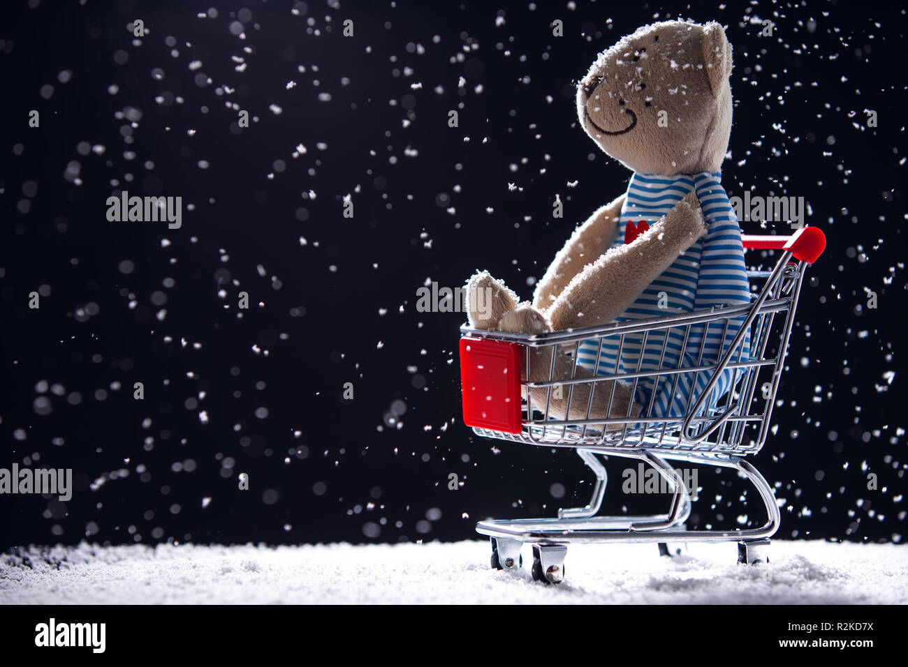 Carrello spesa e Teddy bear bambola isolato. Shopping di Natale sfondo. Foto Stock