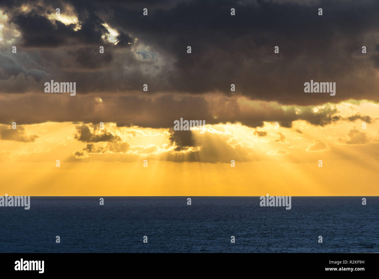 Drammatica moody alba con nuvole scure sull'oceano. Foto Stock