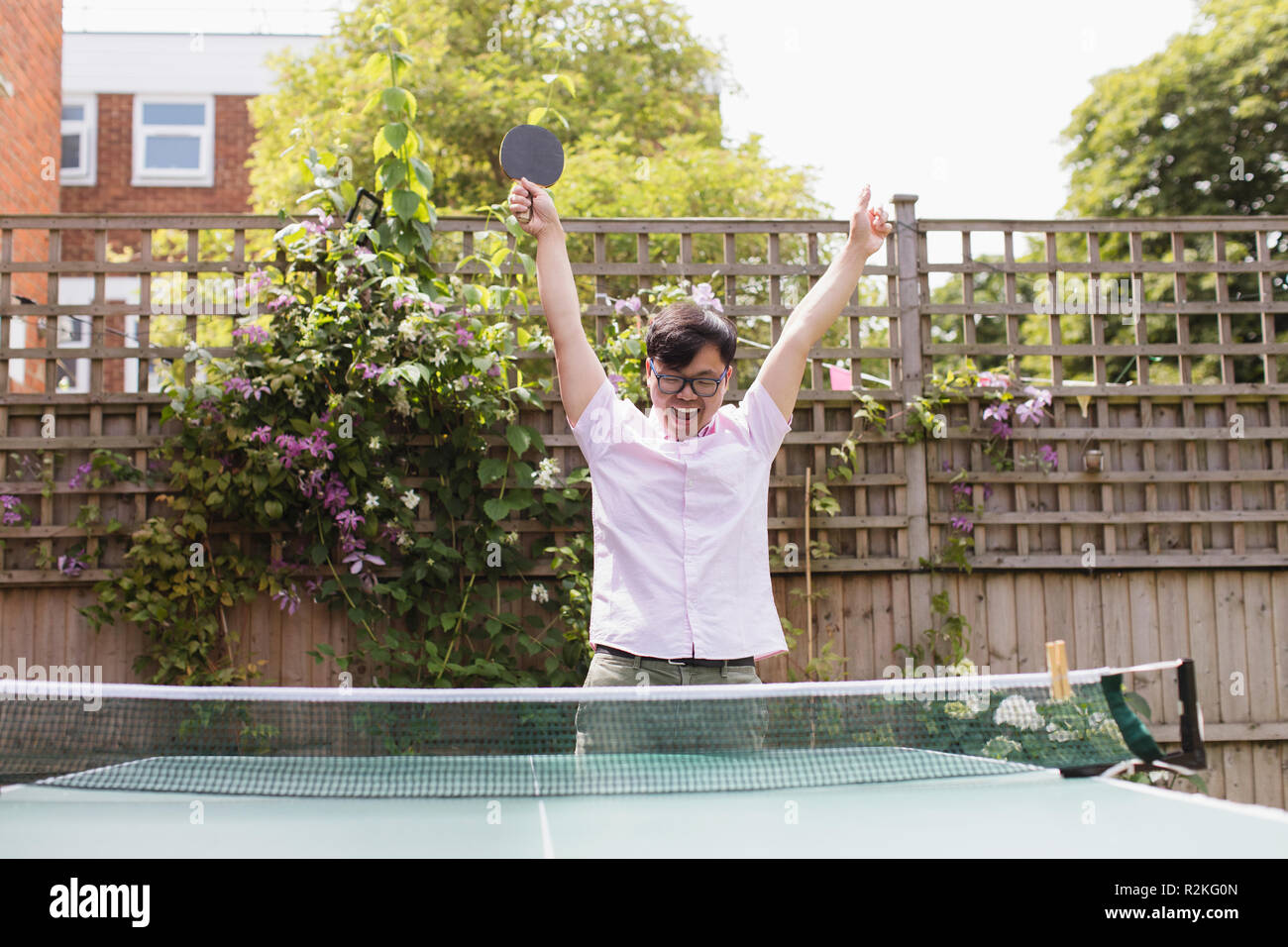 Esuberante uomo giocando a ping-pong, celebrando Foto Stock