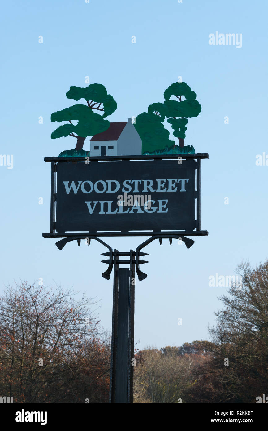 Il villaggio di decorativo segno sul verde in Wood Street Village nel Surrey, Regno Unito Foto Stock