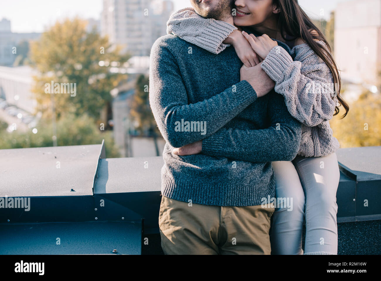 Ritagliato colpo di coppia giovane abbracciando sul tetto Foto Stock