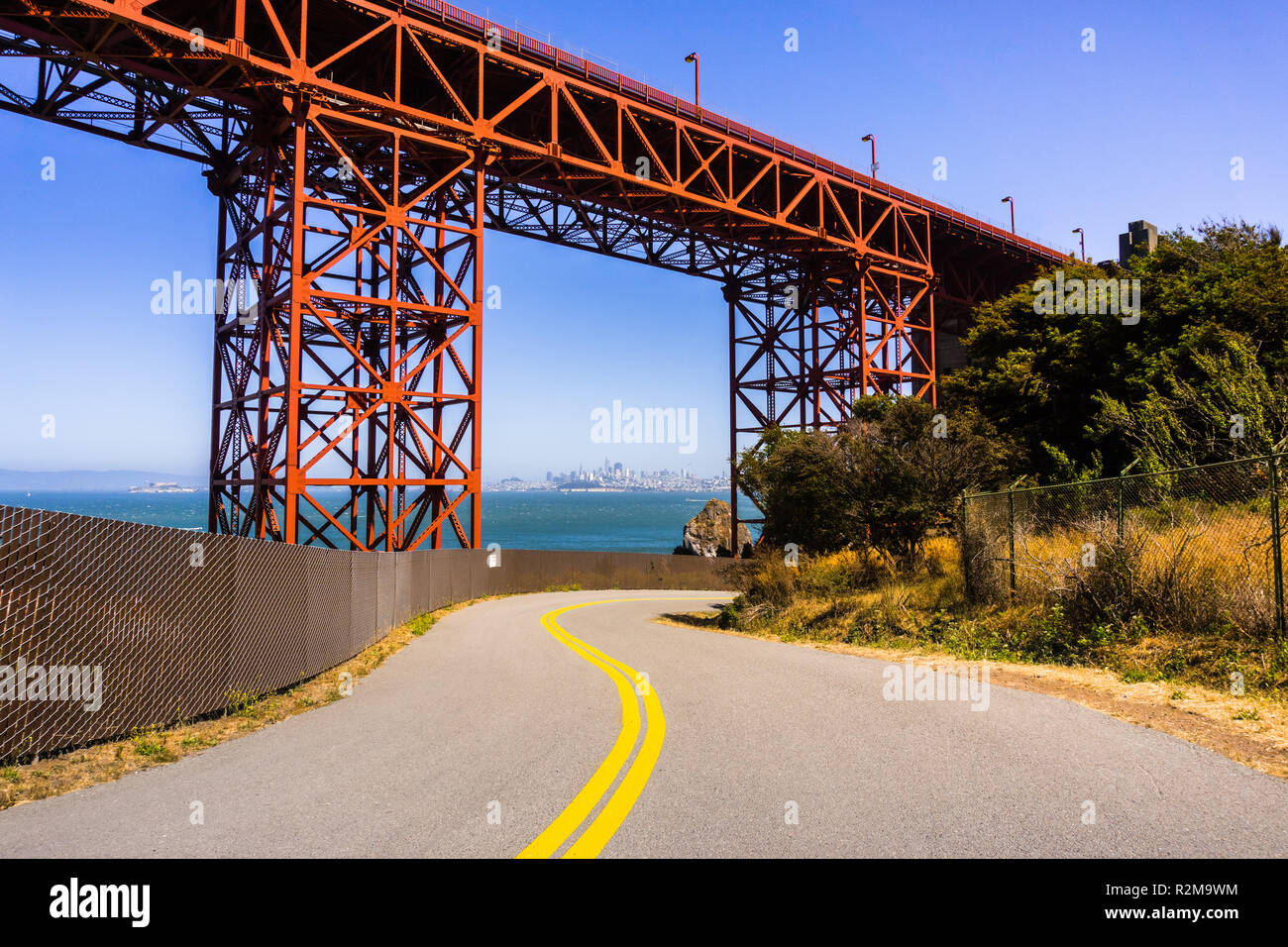 Road passando sotto il Ponte Golden Gate, lo skyline di San Francisco visibile in background; California Foto Stock