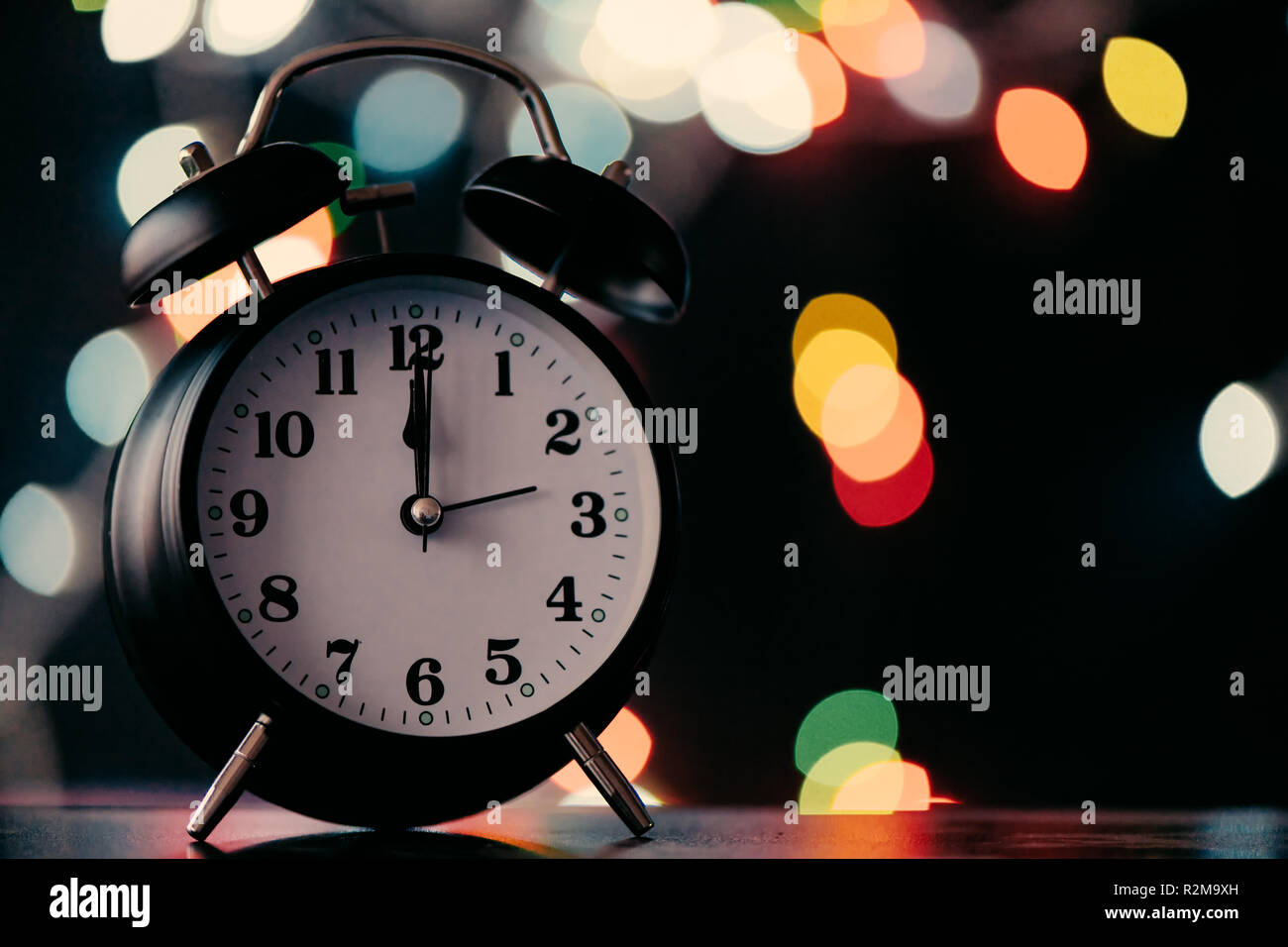 Nuovo Anno di mezzanotte retrò orologio con luci bokeh di fondo in background Foto Stock