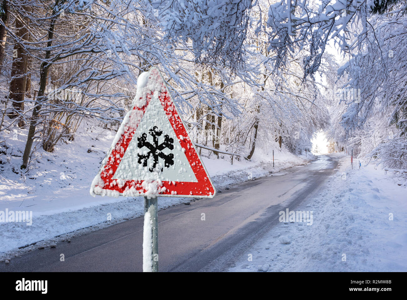 Un segnale di avviso nella parte anteriore della neve sulla strada rurale Foto Stock