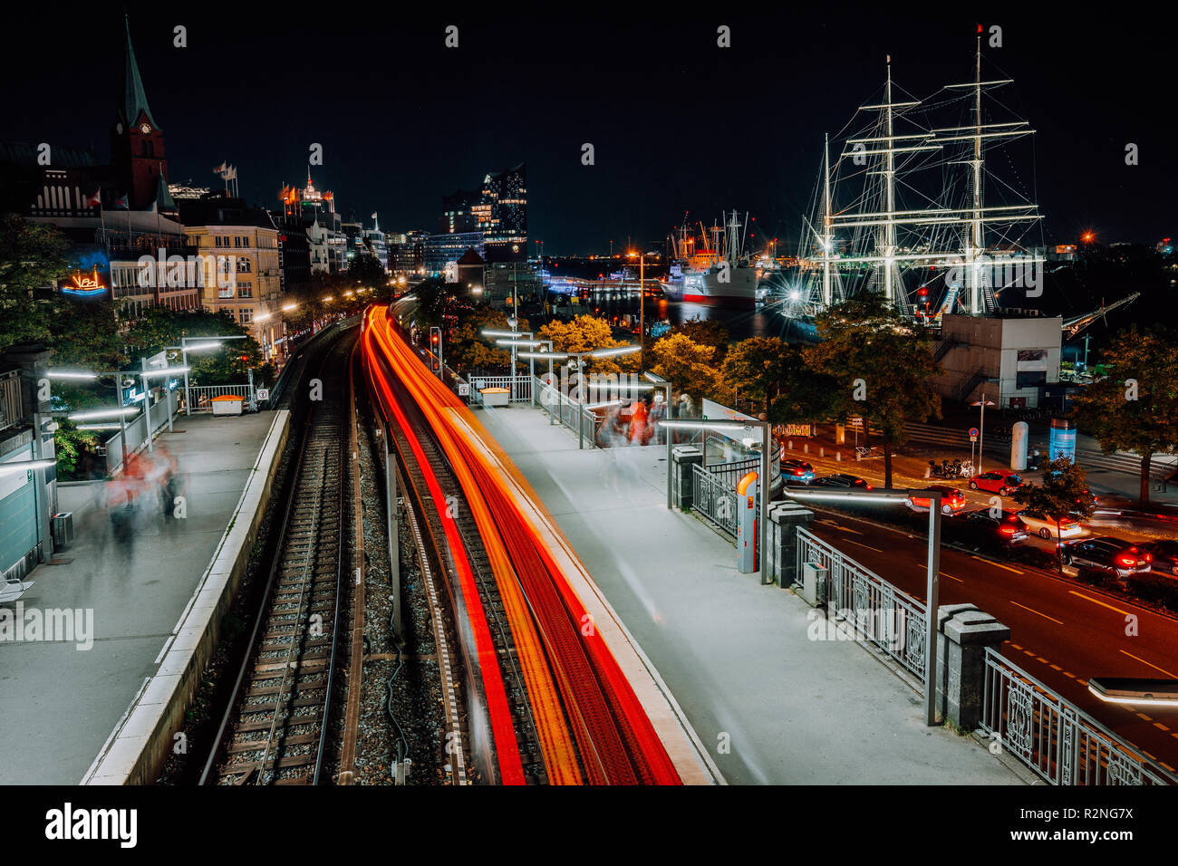 Landungsbruecken ad Amburgo di notte. Incredibili sentieri di luce dal treno in movimento. Paesaggio urbano di Porto e stazione della metropolitana, Germania. Lunga exposue shot Foto Stock