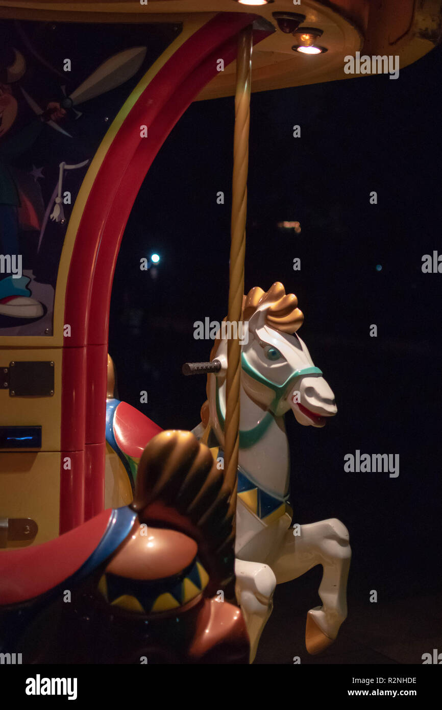 Tasto basso ingrandimento di un cavallo di un merry-go-round, con luce e shadown giocando sulle curve morbide del cavallo Foto Stock