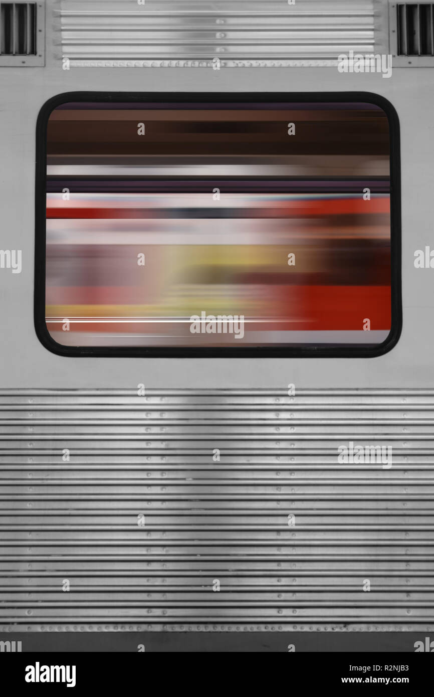 La riflessione astratta di un treno che passa in una finestra del treno di un altro treno, Foto Stock