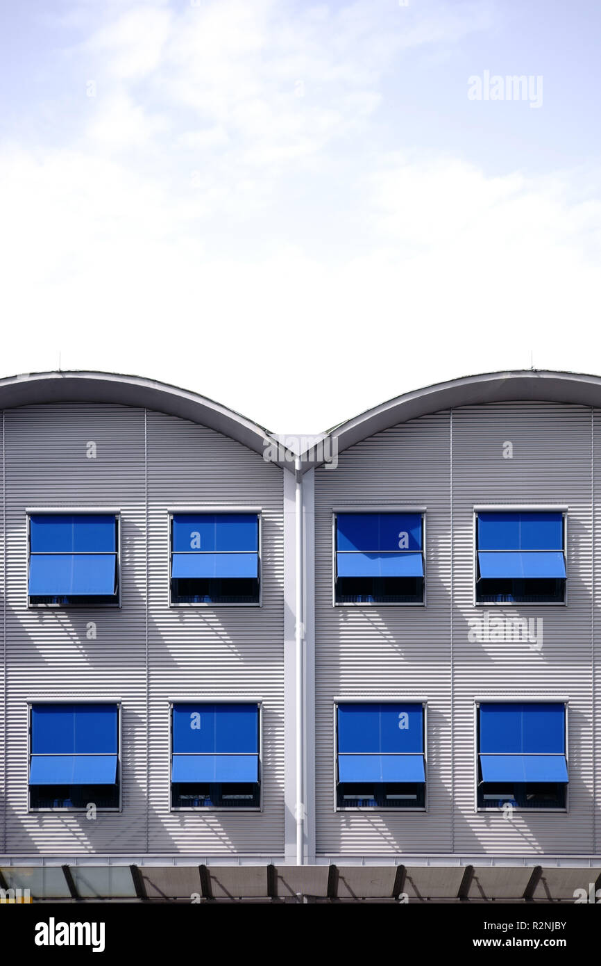 Moderna di ferro ondulato facciata di un edificio residenziale con file di finestre e tende da sole di fronte alle finestre, Foto Stock