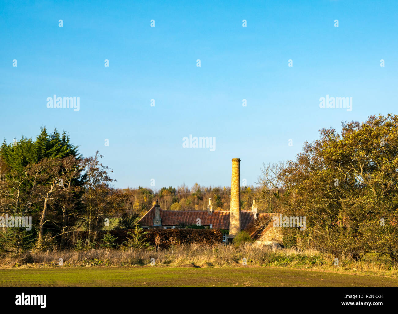 Il vecchio industriale ciminiera in mattoni a convertita fattoria e cottage, Fiume Tyne, East Lothian, Scozia, Regno Unito Foto Stock