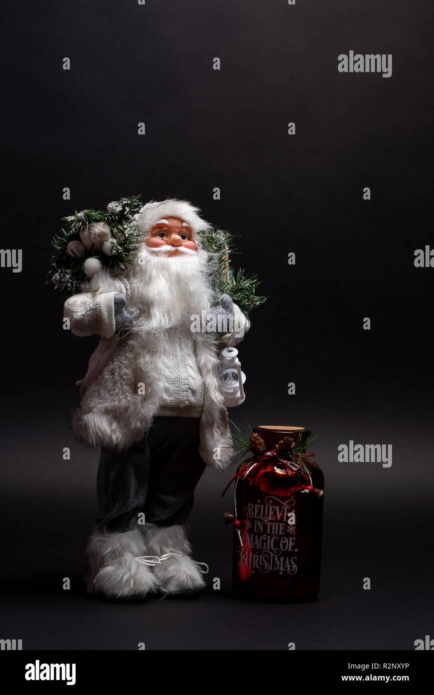 Santa Claus giocattolo con un vaso motivazionale per vacanze di Natale e Capodanno. Credo nella magia di dicembre stagione jolly Foto Stock