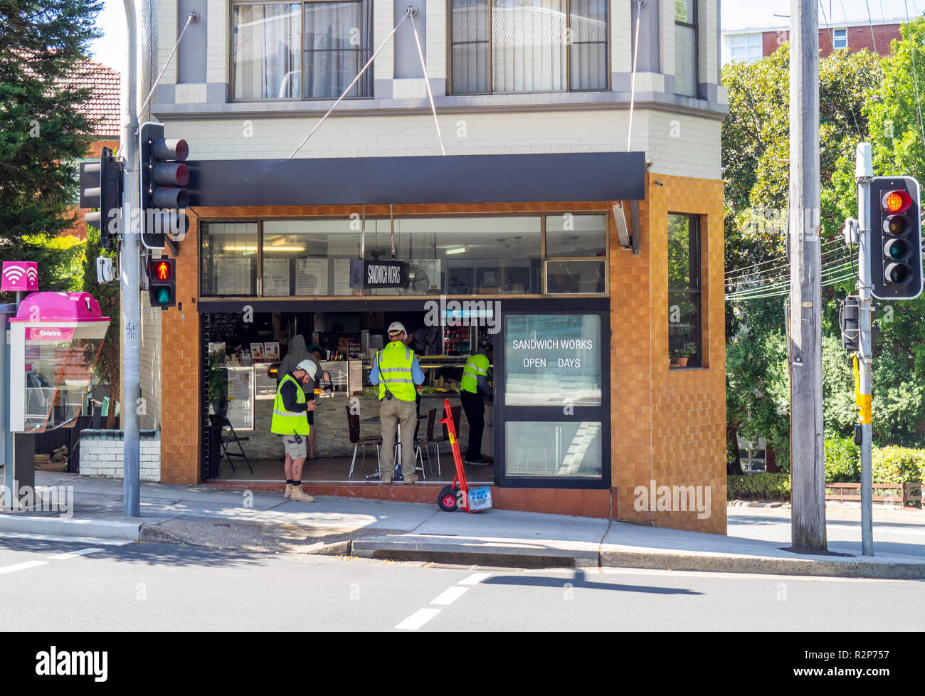 Tre operai acquistando uno snack in un panino angolo bar shop Foto Stock