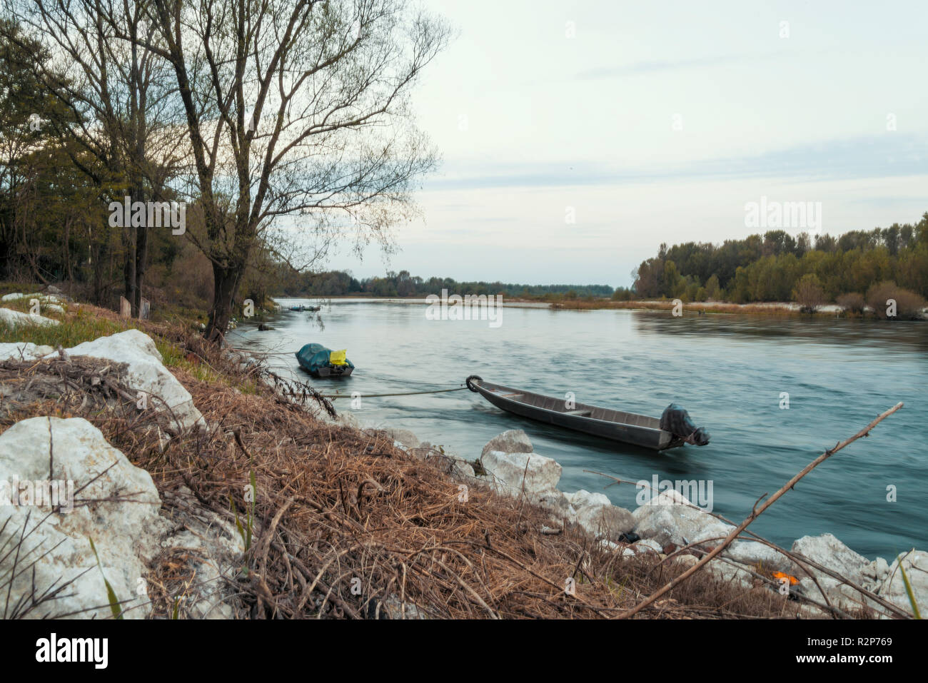 Barche ormeggiate lungo le rive del fiume Ticino al tramonto Foto Stock