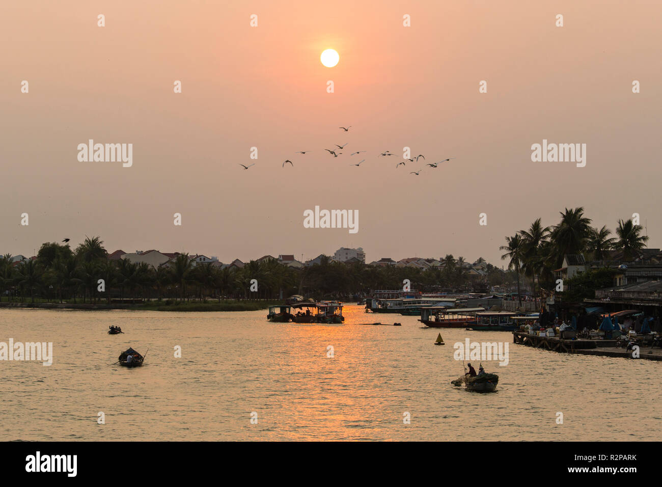 Atmosfera serale, bassa Sun al di sopra di fiume in Hoi An, Vietnam, tornando di barche da pesca Foto Stock