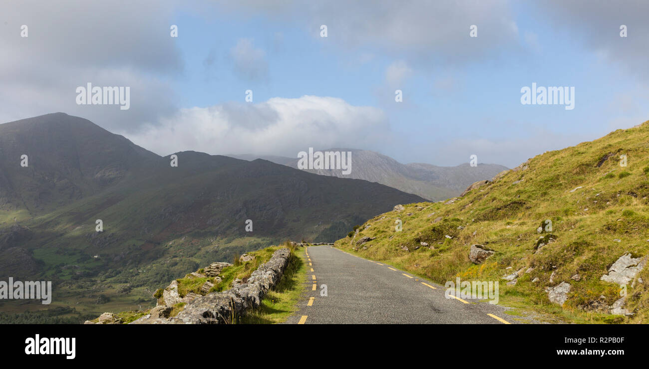 Strada asfaltata nel bellissimo paesaggio verde con le montagne e le nuvole, anello di Beara, Irlanda, panorama Foto Stock