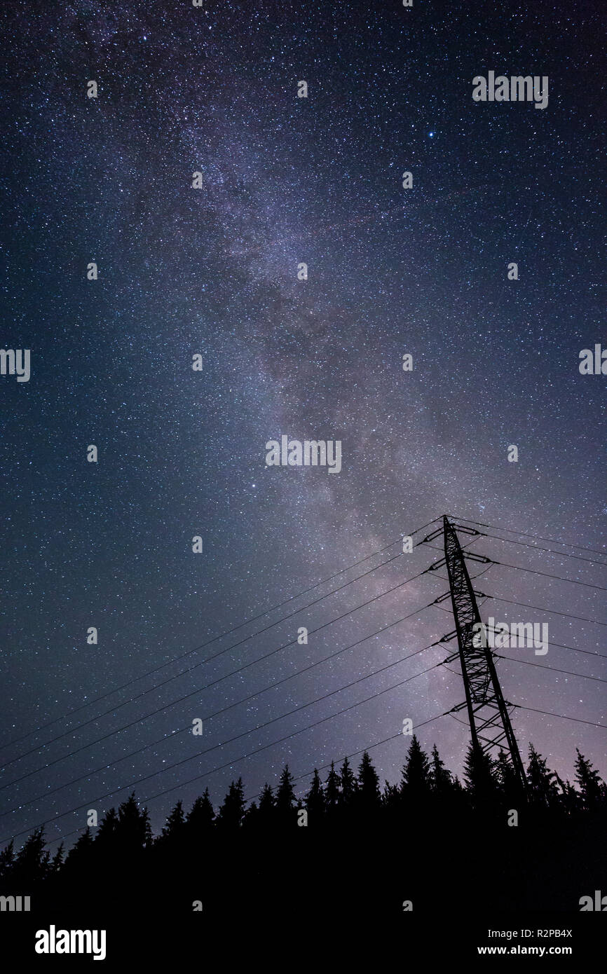 Via lattea sopra la foresta e la torre di trasmissione con stella cadente Foto Stock