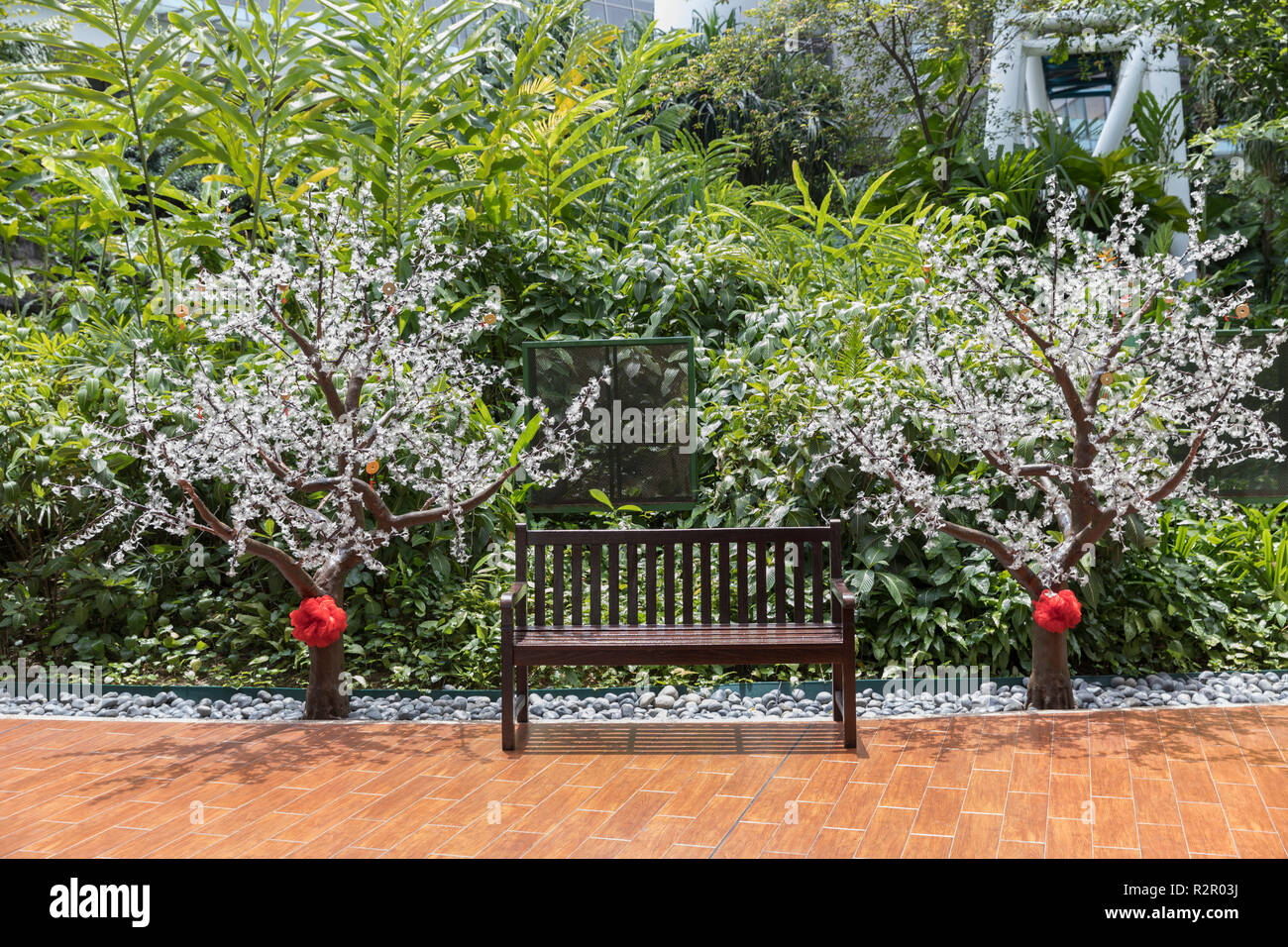 Singapore, edificio del terminal principale di Singapore Flyer, atrio centrale, scoperta della foresta pluviale, banco e gli alberi di plastica Foto Stock