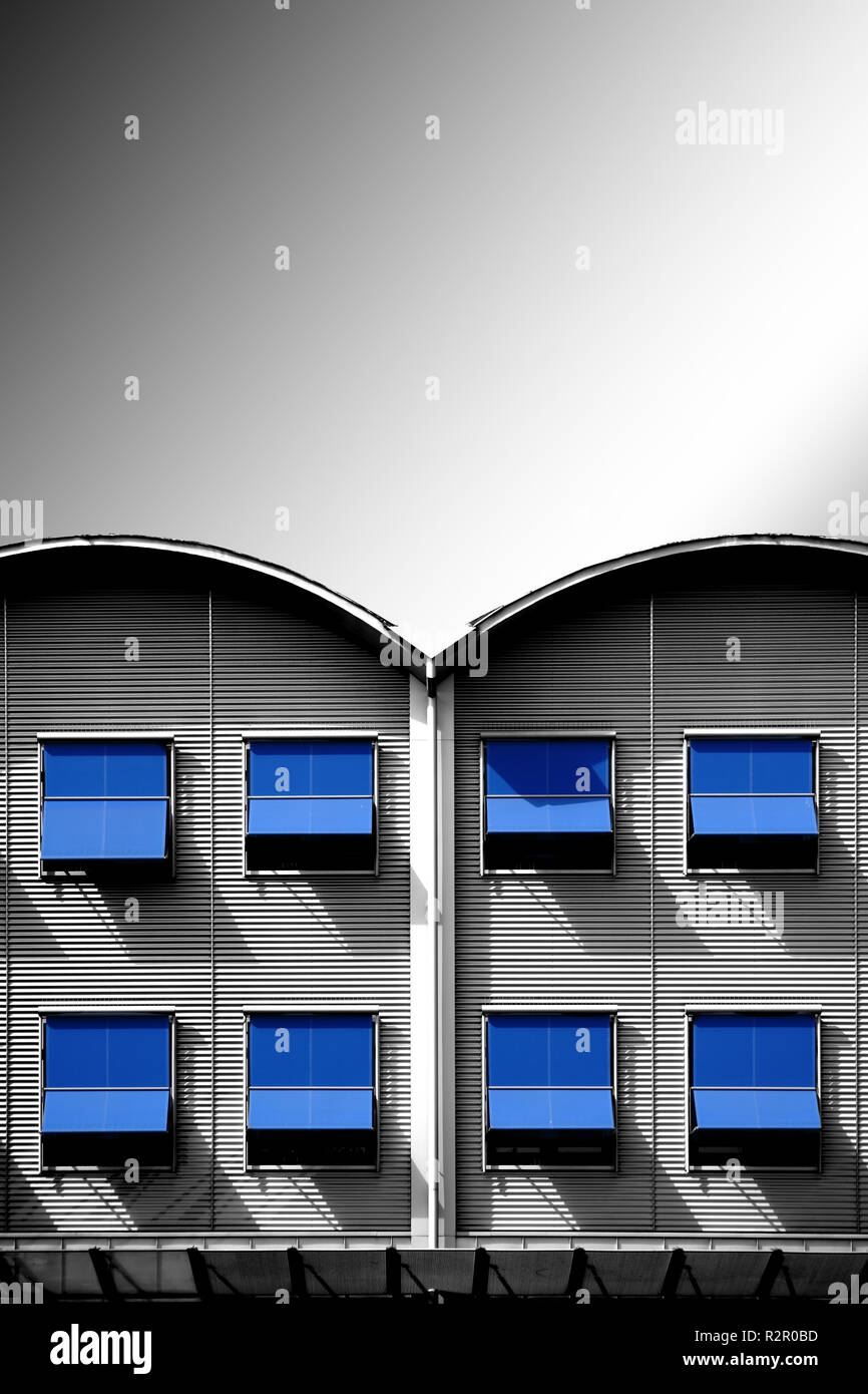 Moderna di ferro ondulato facciata di una casa residenziale con file di finestre e tende blu Foto Stock