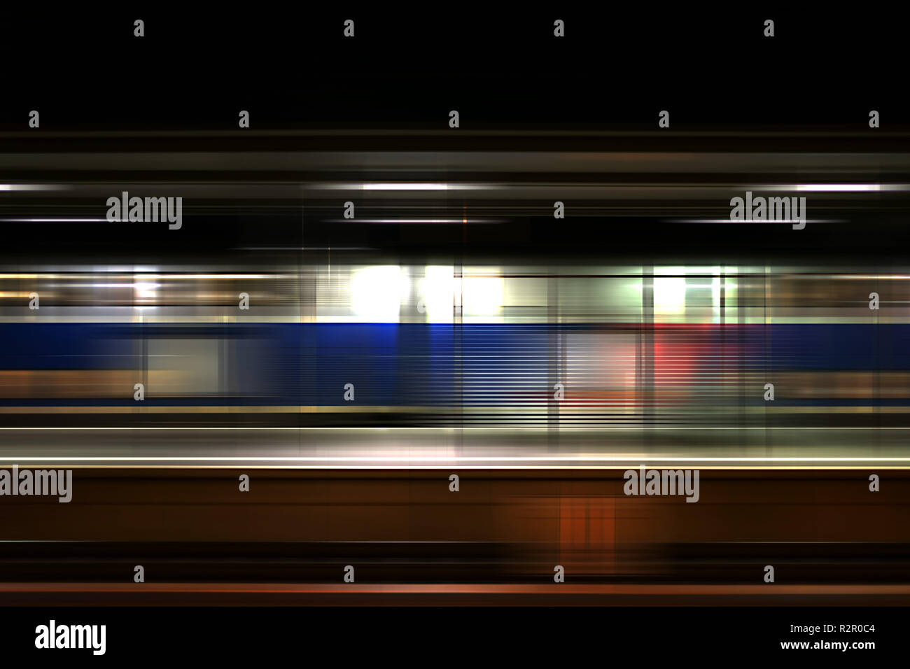 Piattaforma di Weinheim station di notte, posti in vetro parete divisoria, passando il treno Foto Stock