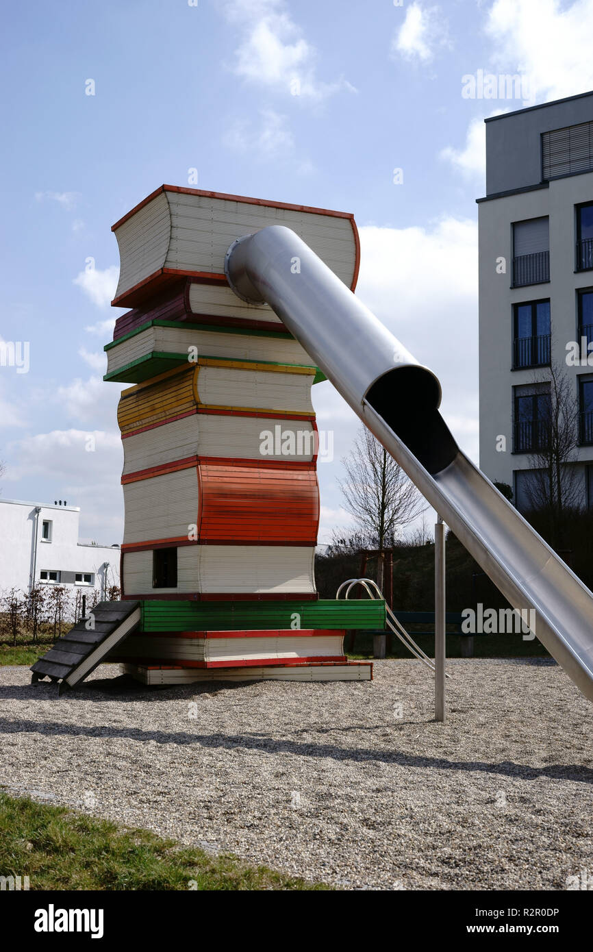 Città moderna parco giochi, scorrere con una scala modellato su una pila di libri, letto di ghiaia Foto Stock