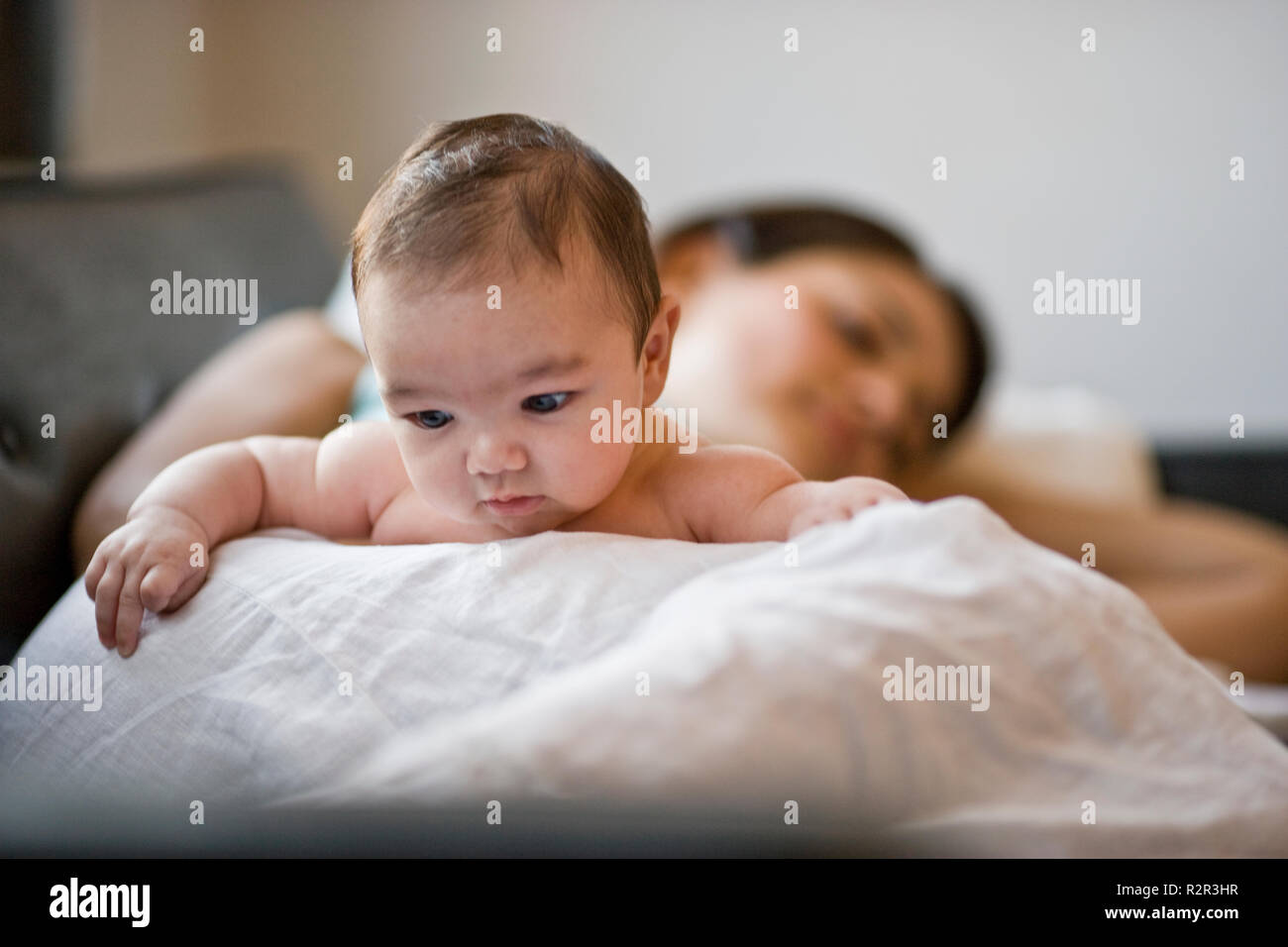 Carino il bambino che giace con sua madre stanco su un divano. Foto Stock