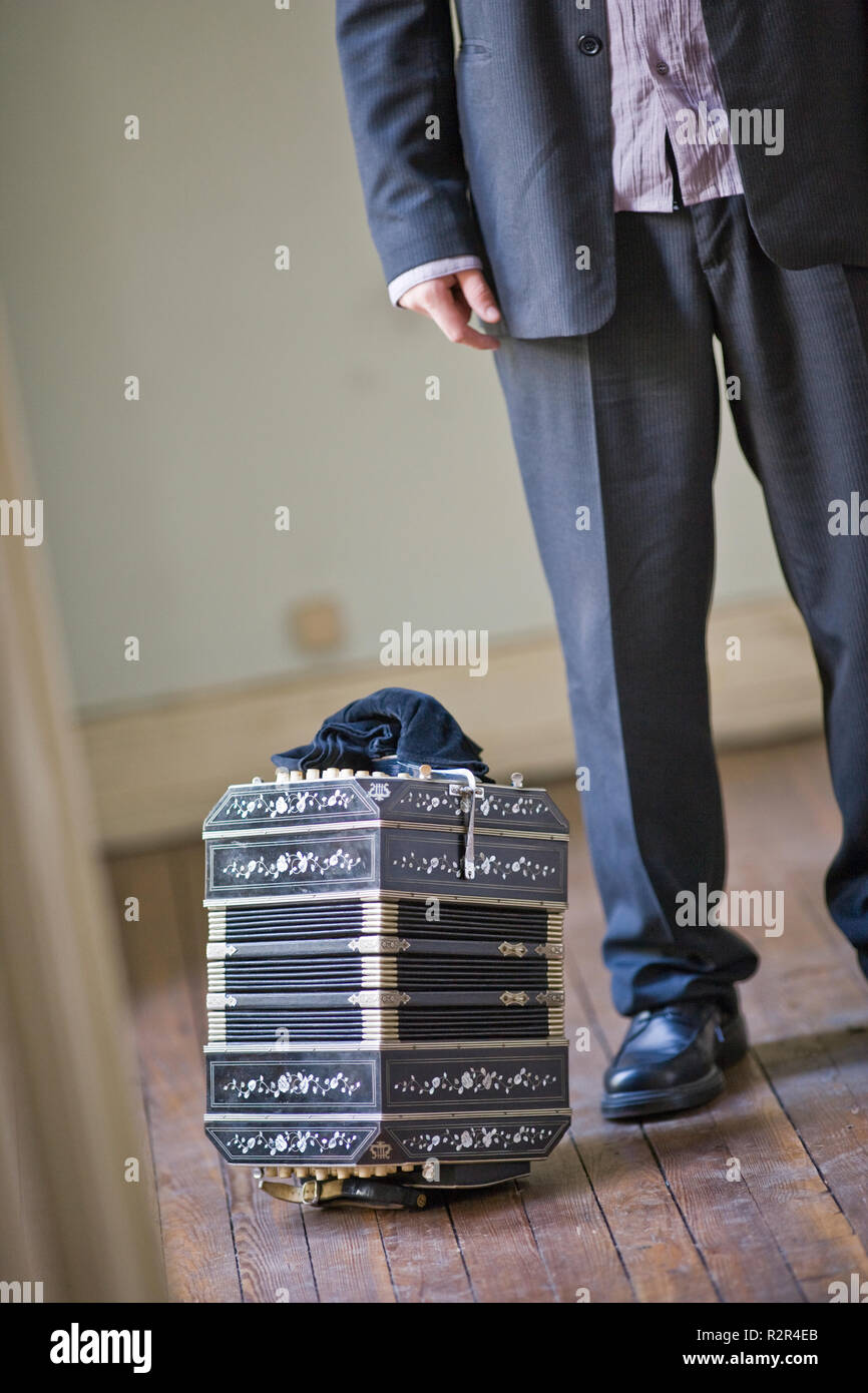 Le gambe e la fisarmonica di un giovane adulto uomo in una stanza. Foto Stock