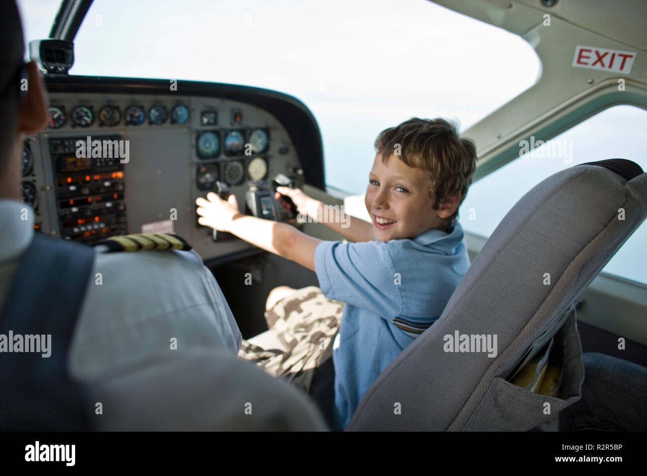 Ritratto di un eccitato ragazzo seduto ai comandi di un aereo. Foto Stock