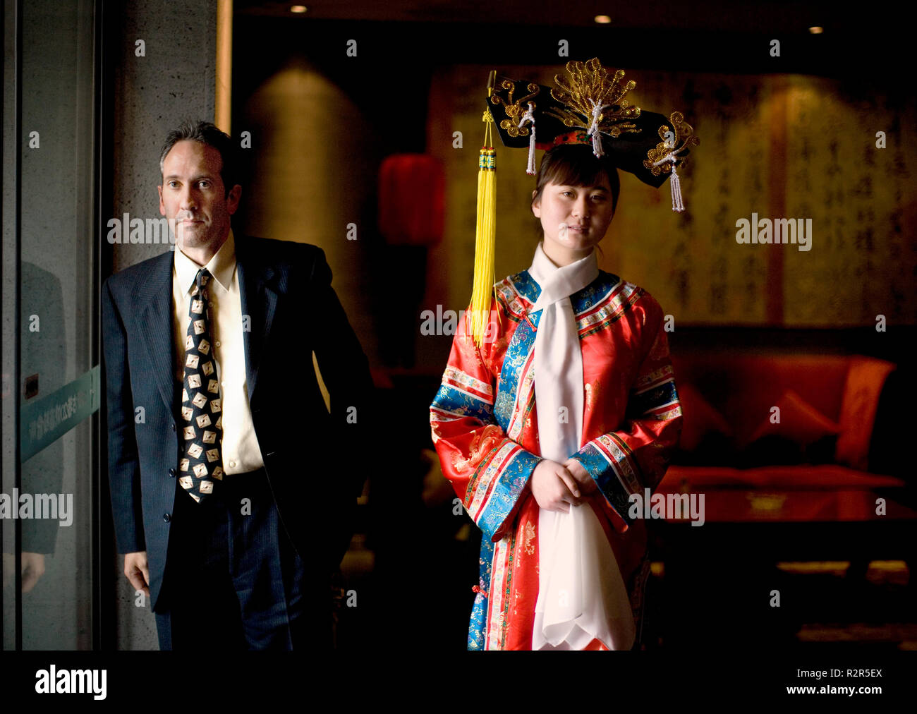 Ritratto di una giovane donna adulta indossando costumi tradizionali con un mid-imprenditore per adulti. Foto Stock